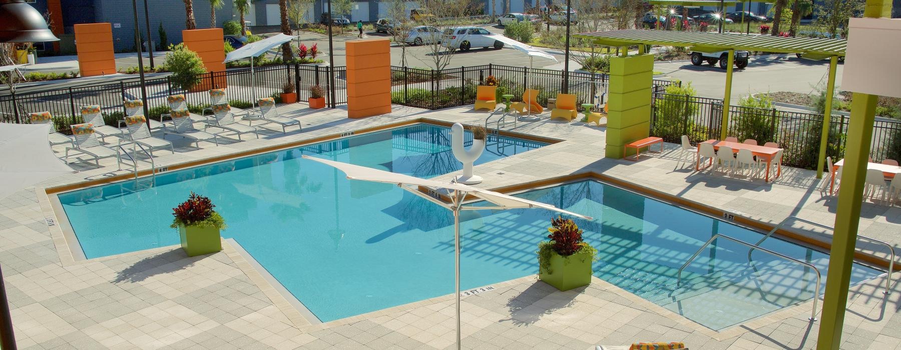 a pool with chairs and tables by it